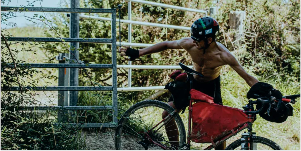 keto athlete leaning against a metal gate in a natural setting